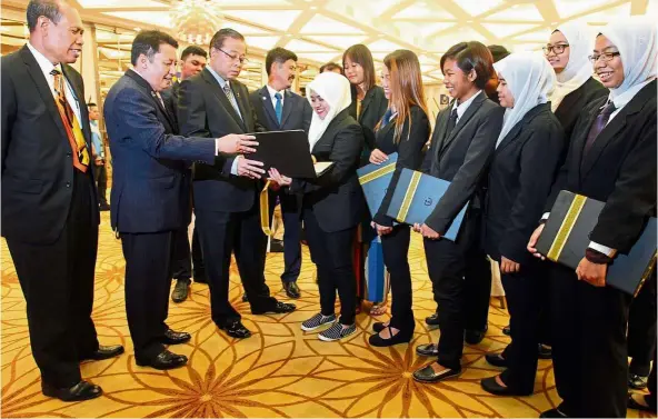  ??  ?? Ismail (third from left) sharing a light moment with the orang asli students who will be pursuing their studies overseas.