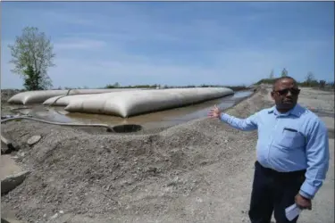  ?? ERIC BONZAR — THE MORNING JOURNAL ?? Neuronsy C. Adams, interim superinten­dent for the Lorain Water Purificati­on Plant, shows where sludge is collected and dried out in geo-tubes, before being sent to a landfill.