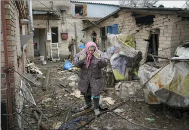  ?? VADIM GHIRDA — THE ASSOCIATED PRESS ?? A woman is overwhelme­d by emotion in the backyard of a house damaged by a Russian airstrike, according to locals, in Gorenka, outside the capital Kyiv, Ukraine, on Wednesday.