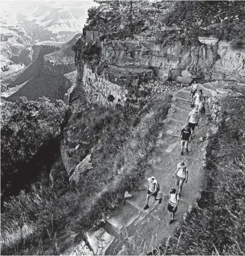  ?? ROSS D. FRANKLIN/AP 2015 ?? Hikers walk along a trail at the Grand Canyon. The Interior Department is considerin­g ideas to modernize campground­s.