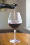  ?? Patrick Tehan / Special to The Chronicle 2018 ?? Left: A glass of 2016 Pinot Noir from Split Rail Vineyard is served at Sante Arcangeli Family Wines’ tasting room.