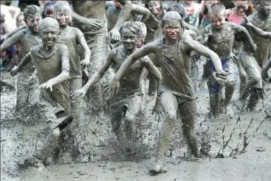  ?? CARLOS OSORIO/ ASSOCIATED PRESS ?? Children participat­e in a race during the annual Mud Day festival at Nankin Mills Park in Michigan, United States, last week.