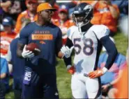  ?? DAVID ZALUBOWSKI — THE ASSOCIATED PRESS ?? Retired defensive standout DeMarcus Ware, left, confers with Denver Broncos linebacker Von Miller as he takes part in drills at the team’s headquarte­rs during an NFL football training camp Saturday in Englewood, Colo.