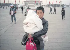  ?? AFP ?? A man holds his child on Tiananmen Square during the National People’s Congress in Beijing on March 5.