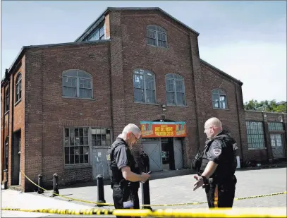  ?? Mel Evans ?? The Associated Press Police stand guard Sunday outside the warehouse building where a shooting left one dead and 22 injured in Trenton, N.J.