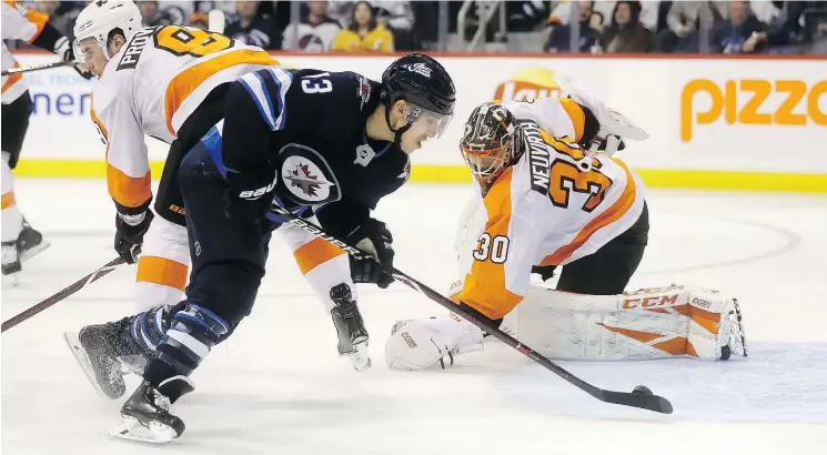  ?? — THE CANADIAN PRESS ?? The Jets’ Brandon Tanev has Flyers goalie Michal Neuvirth at his mercy as he prepares to flip the puck into the net on Sunday in Winnipeg. The Jets won 7-1.