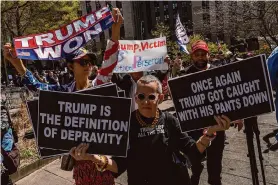  ?? Adam Gray/AFP via Getty Images ?? Pro-Trump and anti-Trump demonstrat­ors hold up signs outside of Manhattan Criminal Court. The trial could last up to two months.