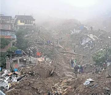  ?? ?? TRAGEDY: Rescue workers and residents look for victims after landslides in Petropolis.