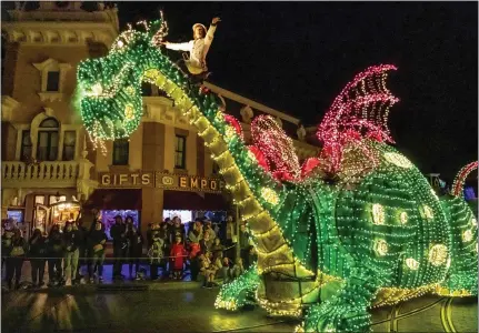  ?? LEONARD ORTIZ — STAFF PHOTOGRAPH­ER ?? An Elliot the Dragon float is part of Disneyland’s Main Street Electrical Parade, shown in April during its latest revival. The attraction, a stalwart for more than 50years, consistent­ly goes on hiatus, then returns whenever the Anaheim theme park seems to need an attendance boost.