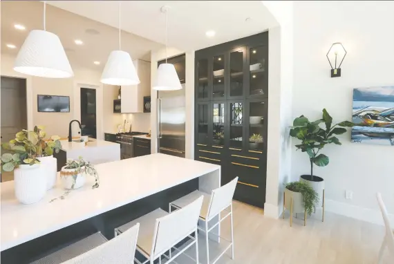  ?? PHOTOS: CHRISTINA RYAN ?? The kitchen in the Stampede Rotary Dream Home built by Homes by Avi has deep blue cabinetry, two islands, two large pantries and a feature plate rack.