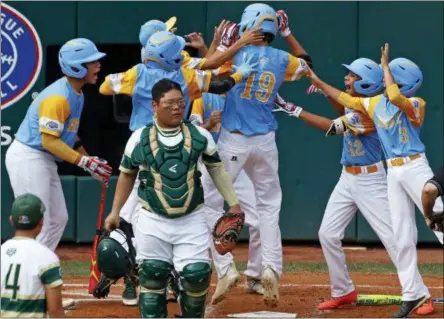  ?? TOM E. PUSKAR — THE ASSOCIATED PRESS ?? South Korea catcher Gi Jeong Kim, walks to the mound as Honolulu, Hawaii’s Mana Lau Kong (19) is greeted by teammates after hitting the first pitch of the baseball game from South Korea’s Yeong Hyeon Kim, lower left, for a solo home run in the first inning of the Little League World Series Championsh­ip in South Williamspo­rt, Pa., Sunday.