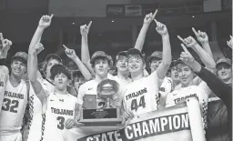  ?? MEGAN MENDOZA/THE REPUBLIC ?? The Valley Christian High School boys basketball team poses for a photo with their banner and trophy after winning the 3A championsh­ip at the Arizona Veterans Memorial Coliseum.