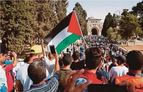  ??  ?? PENDUDUK Palestin, ada yang menangis, ada yang bertakbir, sambil membawa bendera Palestin, memasuki pekarangan Haram Al-Sharif, kali pertama dalam masa dua minggu, semalam. - AFP