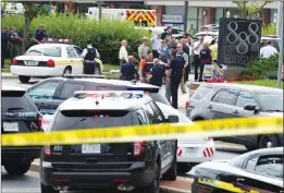  ?? AP PHOTO JOSE LUIS MAGANA ?? Authoritie­s stage at the office building entrance after multiple people were shot at The Capital Gazette newspaper in Annapolis, Md., Thursday.