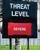  ??  ?? HIGH ALERT:An armed policeman, top, in Londonderr­y after the car-bomb blast and a sign, above, at a military base