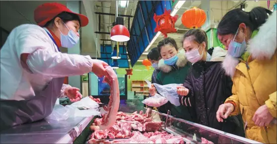  ?? ZHAI HUIYONG / FOR CHINA DAILY ?? Residents buy pork at a supermarke­t in Hai’an, Jiangsu province. Last month, China imported several thousand breeding pigs to boost pork supplies nationwide.