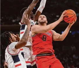  ?? Mary Altaffer/Associated Press ?? St. John’s guard Chris Ledlum (8) goes to the basket against UConn guard Stephon Castle, left, and forward Samson Johnson on Friday in New York.