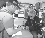  ?? BRIAN SPURLOCK, USA TODAY SPORTS ?? “She said, ‘ You son of a gun! You went home and ate?’ ” says Mario Andretti, signing an autograph.