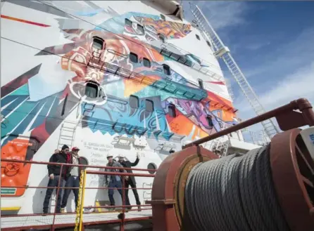  ?? PAUL CHIASSON, THE CANADIAN PRESS ?? Artists Benny Wilding, Fonki, Brian Beyung and Ankh One, from left, stand on the deck of the CSL St-Laurent after signing their artwork during the opening of the 59th navigation season of the St. Lawrence Seaway, Monday in Montreal.