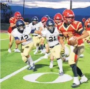  ?? COURTESY OF ROMAN MARTINEZ JR. ?? Santa Fe’s Christian Martinez (21) and Damian Morales (42) chase down Española Valley quarterbac­k Makaio Frazier during the Demons’ win Friday that ended a 35-game losing streak.