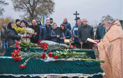  ?? Photos by Alex Babenko/Associated Press ?? A priest conducts a service Saturday at the coffins of Tetiana Androsovyc­h, 60, and her husband, Mykola, 63, who were killed earlier in the week in a missile attack on the northeaste­rn Ukrainian village of Hroza.
