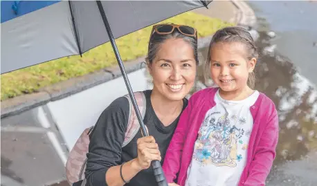  ?? Picture: Nev Madsen ?? SPRING STORMS: Rain clouds did not deter Miyako Hansen and her four-year-old daughter Elsa Hansen from exploring Laurel Bank Park yesterday.