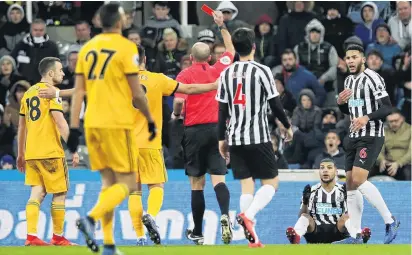  ?? PHOTO: GETTY IMAGES ?? What did I do? Deandre Yedlin, of Newcastle United (grounded), reacts as he is shown a red card by referee Mike Dean and is sent off during the English Premier League match between Newcastle United and Wolverhamp­ton Wanderers at St James Park in Newcastle yesterday.