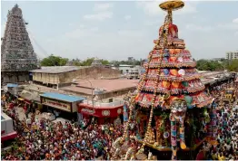  ?? — AFP ?? Hindu devotees pull a chariot decorated with flowers and statues of Hindu god Kapaleeswa­r during a festival in Chennai on Wednesday.