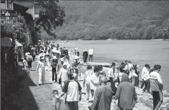  ?? WU AILING / FOR CHINA DAILY ?? Visitors gather at the Ancient Weir-Home of Painting scenic area in Lishui.