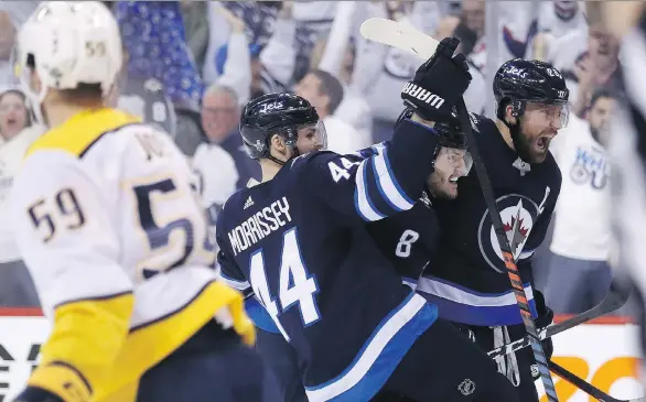  ?? TREVOR HAGAN/THE CANADIAN PRESS ?? Josh Morrissey, Jacob Trouba and Blake Wheeler celebrate one of Winnipeg’s seven goals in a win over Nashville on Tuesday to take the series lead.