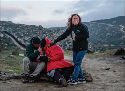  ?? ?? Migrants from Panama and Peru break down crying after arriving at the campsite. A group of about 300 fought bitter winds and rough terrain to cross the border.