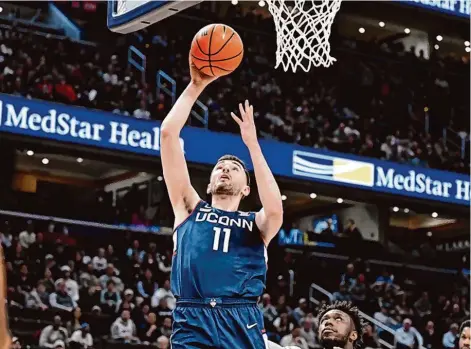  ?? Greg Fiume/Getty Images ?? UConn’s Alex Karaban goes up for a layup against Georgetown on Saturday.