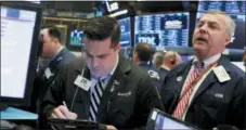  ?? RICHARD DREW — THE ASSOCIATED PRESS FILE ?? Joseph Lawler, left, and James Lamb work on the floor of the New York Stock Exchange.