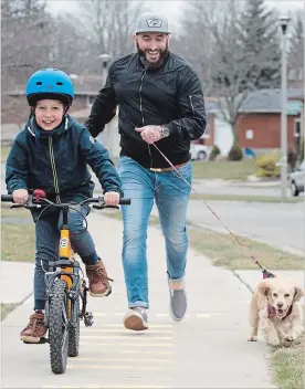  ?? PETER LEE WATERLOO REGION RECORD ?? Nick De Leo runs to keep up with his son Romeo, 8, riding his bike, while holding the leash of their dog Mila on Glen Forrest Boulevard, Waterloo, on Tuesday.