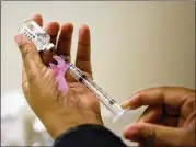  ?? DAVID GOLDMAN / AP ?? A nurse prepares a flu shot at the Salvation Army in Atlanta. The U.S. government’s Friday flu report showed the flu has further tightened its grip on the U.S. This season is now as intense as the swine flu epidemic nine years ago.