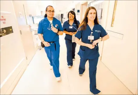  ?? Mel Melcon Los Angeles Times ?? DAVID FUENTES makes the rounds with nurses Pamela Helms, center, and Heather Alfano at UCLA Medical Center, Santa Monica. His mother was unable to become a nurse, so “I wanted to fulfill for my mom what she envisioned for herself, but could never do,”...