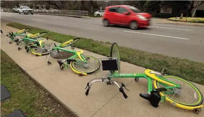  ?? Max Faulkner/Fort Worth Star-Telegram ?? A group of Lime Bikes lay overturned on a sidewalk along Lemmon Avenue in Dallas. The city is scheduled to pass regulation­s on shared transporta­tion in May.