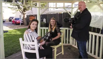  ??  ?? TG4/Hup cameraman Paschal Cassidy preparing to film musicians and Brosna Céilí Band members, Jean Scannell (left) and Gretta Curtin at Nana Bea’s Restaurant Garden on Saturday afternoon. Photo: John Reidy