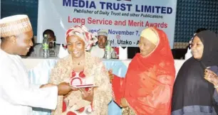  ?? Photos: Ikechukwu Ibe and Abdul Musa ?? CEO/Editor-in-Chief Media Trust Ltd., Mannir Dan Ali presents the company’s integrity and ethical conduct award to Yusuf Aisha Abdullahi of Finance Department (2nd left), during Media Trust long service and merit awards ceremony in Abuja on Tuesday