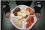  ?? WONG MAYE-E - THE AP ?? A 7th grader carries her plate which consists of three bean chili, rice, mandarins and cherry tomatoes and baked chips during her lunch break at a local public school, Saturday, Feb. 11.