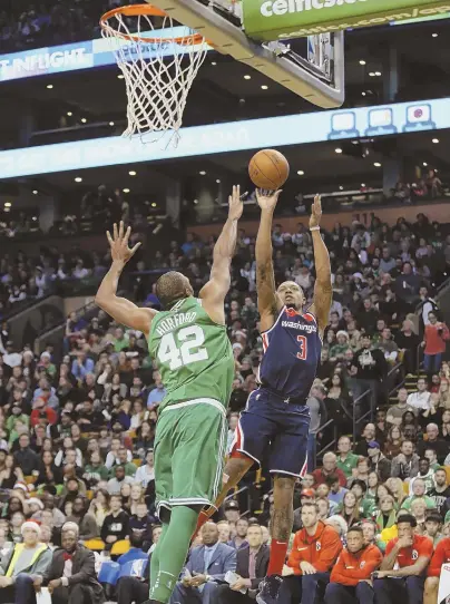  ?? STAFF PHOTO BY NICOLAUS CZARNECKI ?? FLYING HIGH: Bradley Beal shoots over Al Horford during yesterday’s game at the Garden.