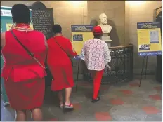  ?? (File photo/AP/Martha Waggoner) ?? Visitors look at items marking the 100th anniversar­y of the passage of the 19th Amendment in September 2019 at the State Capitol in Raleigh, N.C. The exhibit was titled, “She Changed the World: NC Women Breaking Barriers.”
