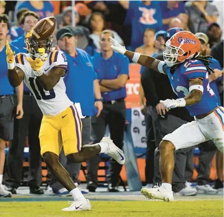  ?? JOHN RAOUX/AP ?? LSU wide receiver Jaray Jenkins makes a reception in front of Florida cornerback Jaydon Hill for a 54-yard touchdown during a 45-35 win Saturday night in the Swamp.