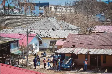  ?? (Foto BERNAMA) ?? Pihak berkuasa terus mengkoordi­nasi kemasukan penghuni kediaman yang terjejas bagi memeriksa keadaan rumah dan harta benda mereka di Kampung Kuala Sungai Baru, Puchong.