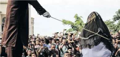  ??  ?? An Aceh woman being flogged. Under the new rules only journalist­s and adults can witness the punishment inside private prisons.