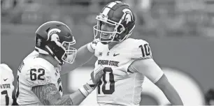  ?? ADAM HUNGER/AP ?? MSU quarterbac­k Payton Thorne (10) celebrates a touchdown with Luke Campbell in the first half against Rutgers on Saturday in Piscataway, N.J.