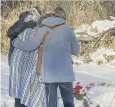  ?? GORD WALDNER/SASKATOON STARPHOENI­X ?? Walking With Our Sisters members on Monday place flowers at the site where Karina Wolfe’s body was found last month.