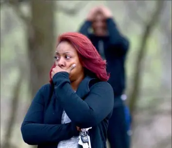  ?? Pam Panchak/Post-Gazette ?? People react to the discovery of a teenage boy shot to death Tuesday at the Linton Middle School playground in Penn Hills.