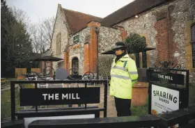  ?? Daniel Leal-Olivas / AFP / Getty Images ?? A police officer stands at a cordon blocking access to The Mill in Salisbury, England. Traces of nerve agent contaminat­ion were found at the pub.