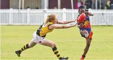  ??  ?? AFL Darling Downs women’s best and fairest Brigette Fee applies pressure to USQ Cougars player Nyengela Mwajuma during their grand final encounter at Rockville Oval.